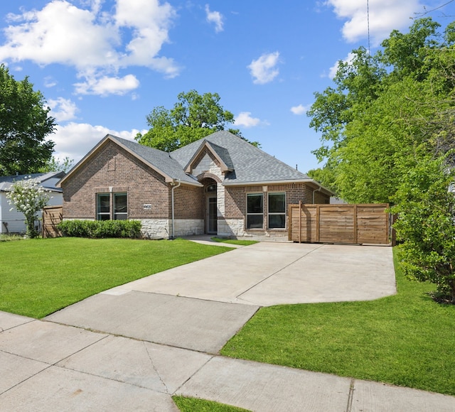 4435 Cicero St, Dallas, TX 75216 - view of front of home featuring a front yard, brick siding, stone siding, roof with shingles, and fence