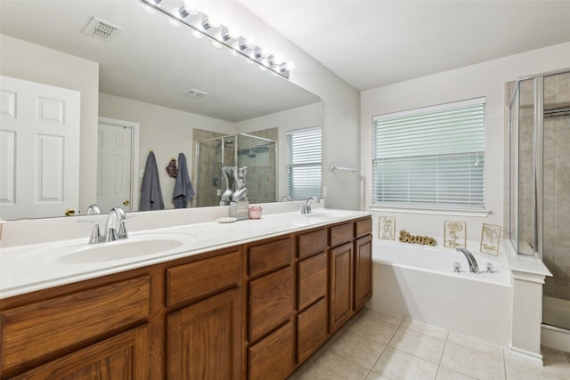 full bath featuring double vanity, a sink, tile patterned floors, and a stall shower