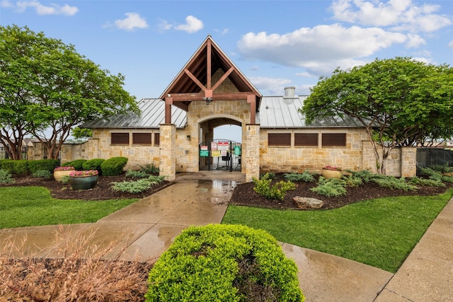 view of front facade featuring a standing seam roof, metal roof, and stone siding
