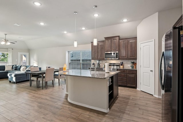 kitchen with open floor plan, ceiling fan, dark brown cabinets, and stainless steel appliances