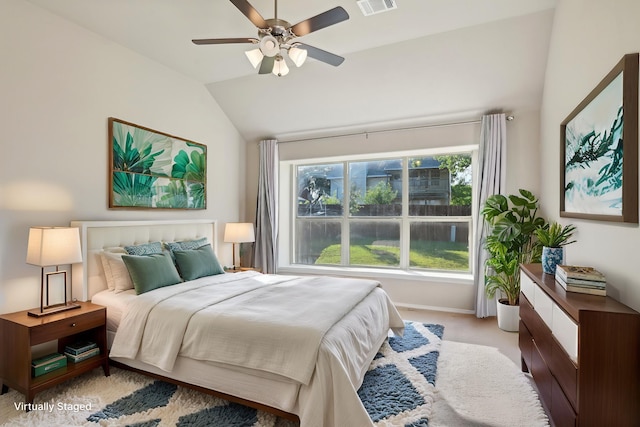 bedroom with visible vents, ceiling fan, baseboards, vaulted ceiling, and light carpet
