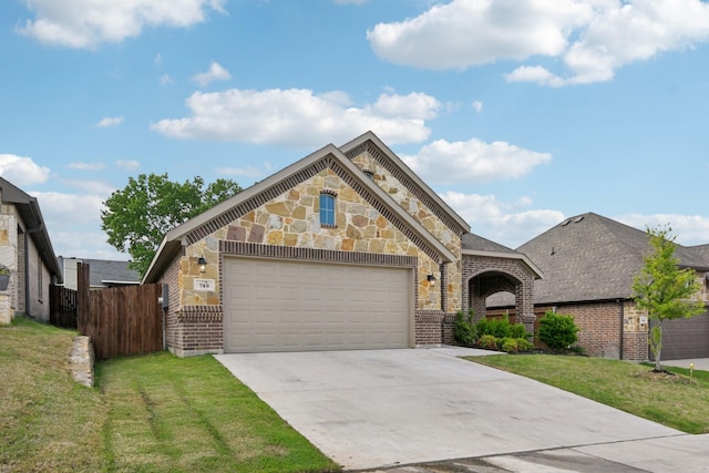 view of front of house with brick siding, fence, a front yard, concrete driveway, and an attached garage