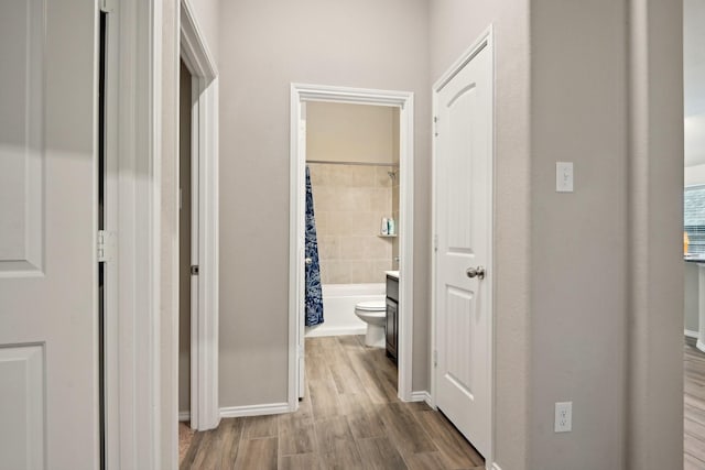 hall with wood finished floors and baseboards