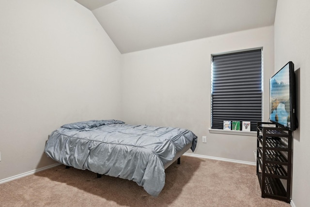 carpeted bedroom with vaulted ceiling and baseboards