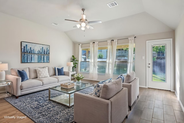 living area with visible vents, lofted ceiling, and a healthy amount of sunlight