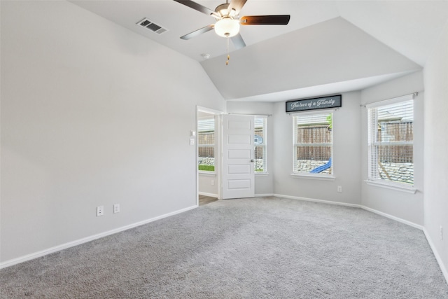 carpeted empty room featuring visible vents, a ceiling fan, vaulted ceiling, and baseboards