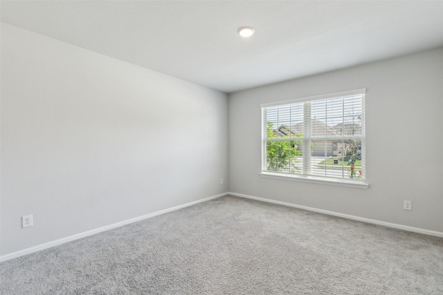 unfurnished room featuring carpet floors and baseboards