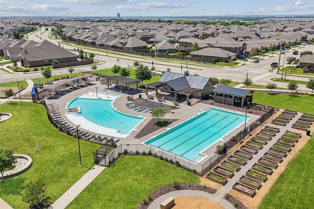 pool featuring fence, a yard, and a residential view