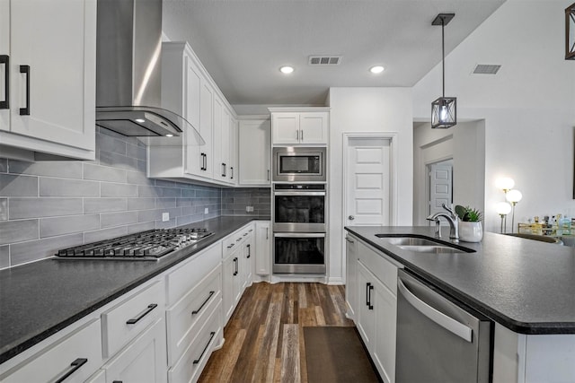 7005 Lowbranch Trl, Little Elm, TX 76227 - kitchen with a sink, stainless steel appliances, visible vents, wall chimney range hood, and dark countertops