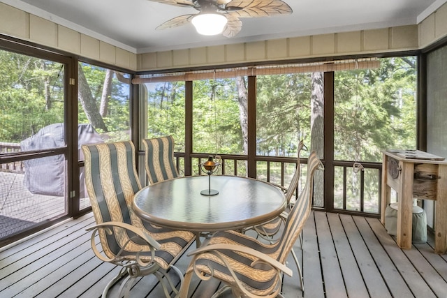 sunroom with a wealth of natural light, outdoor dining area, and a ceiling fan
