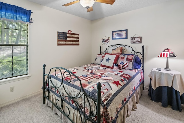 carpeted bedroom featuring a ceiling fan, baseboards, and multiple windows