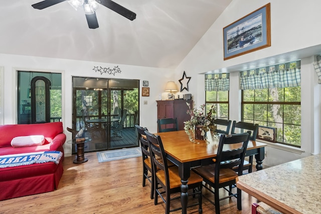 dining room with a ceiling fan, high vaulted ceiling, a wealth of natural light, and wood finished floors