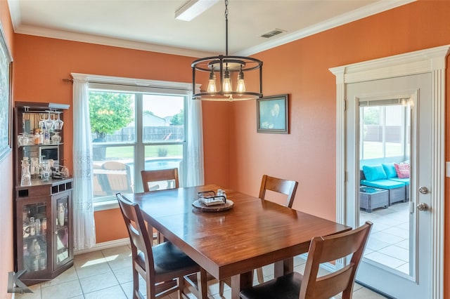 dining space featuring an inviting chandelier, ornamental molding, light tile patterned floors, and a healthy amount of sunlight