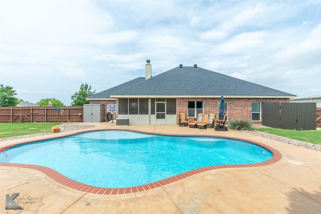 view of swimming pool with a gate, a sunroom, a patio area, a fenced in pool, and a fenced backyard