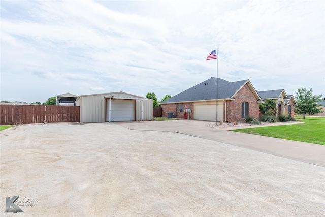 view of front facade with fence, roof with shingles, brick siding, concrete driveway, and a detached garage