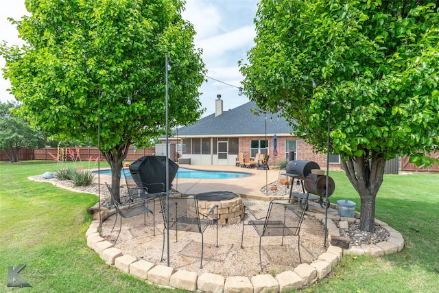 view of swimming pool with a fire pit, a patio, a fenced backyard, a fenced in pool, and a yard