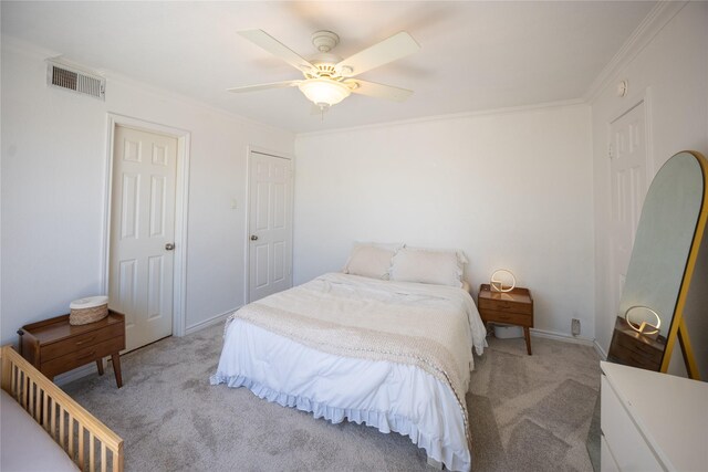 carpeted bedroom featuring baseboards, visible vents, ornamental molding, and ceiling fan