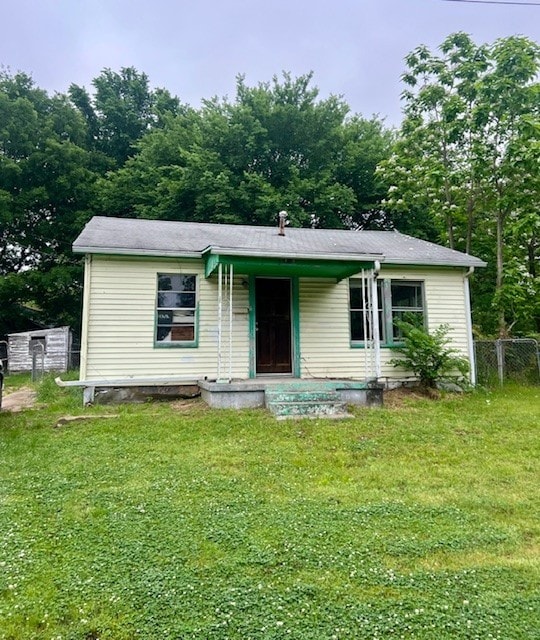 view of front of property with a porch, a front lawn, and fence