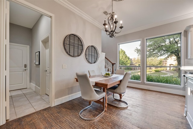 dining space featuring light tile patterned floors, crown molding, visible vents, baseboards, and an inviting chandelier