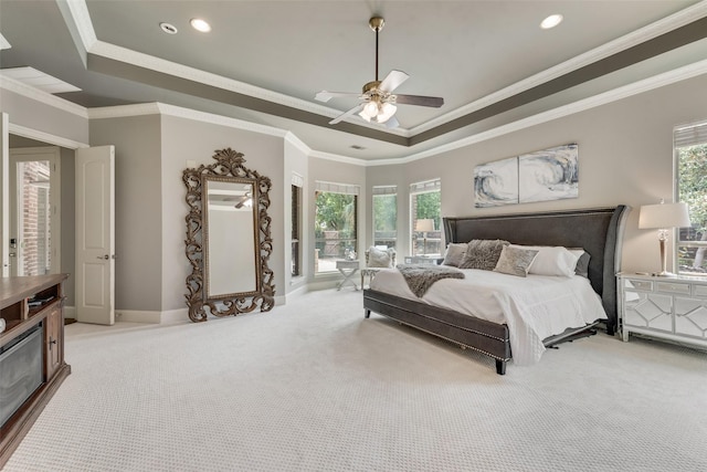 carpeted bedroom with a raised ceiling, recessed lighting, crown molding, and baseboards
