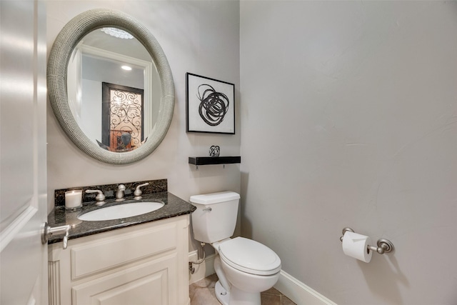 bathroom with baseboards, toilet, tile patterned flooring, and vanity