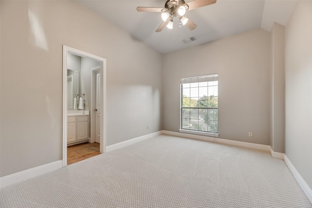 unfurnished bedroom with lofted ceiling, light colored carpet, visible vents, and baseboards
