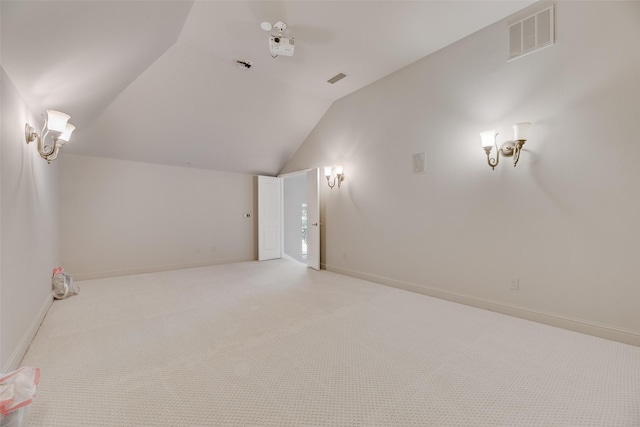 additional living space with lofted ceiling, light colored carpet, visible vents, and baseboards