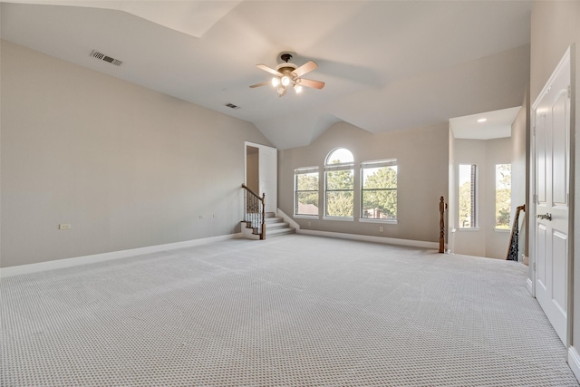 interior space with lofted ceiling, carpet flooring, ceiling fan, visible vents, and baseboards