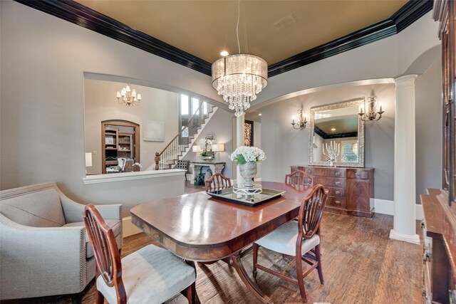 dining space with crown molding, an inviting chandelier, stairway, and wood finished floors