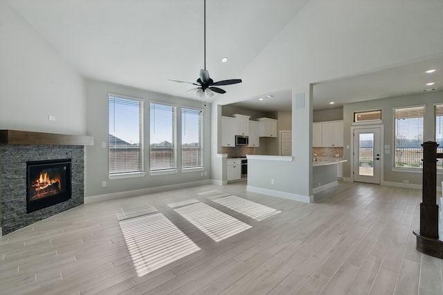 1720 Highwood Rd, Forney, TX 75126 - unfurnished living room featuring baseboards, light wood-type flooring, a ceiling fan, and a fireplace