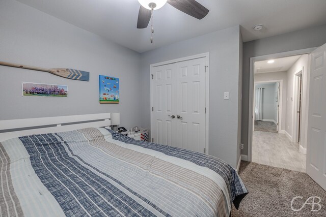 bedroom with a closet, ceiling fan, carpet, and baseboards