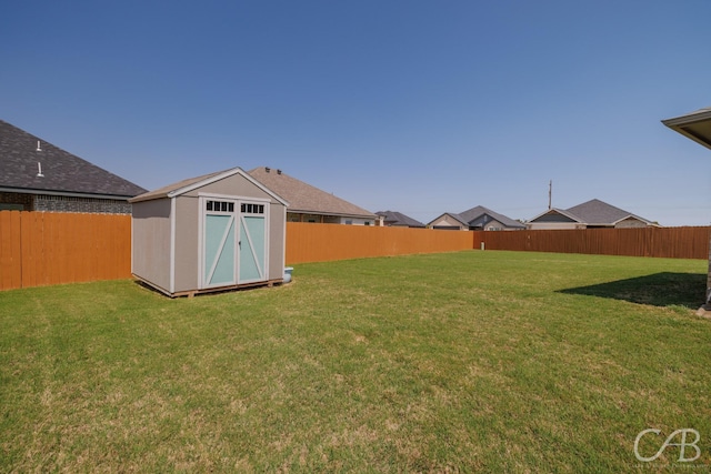 view of yard featuring an outbuilding, a shed, and a fenced backyard