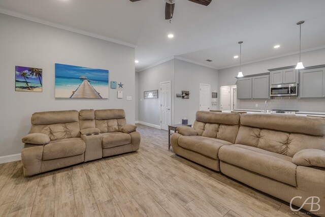 living area with recessed lighting, light wood finished floors, baseboards, a ceiling fan, and crown molding