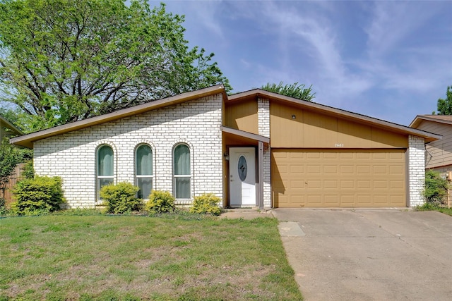 mid-century modern home with a front lawn, driveway, a garage, and brick siding
