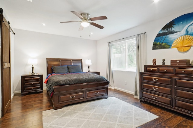 bedroom featuring a barn door, recessed lighting, wood-type flooring, and baseboards