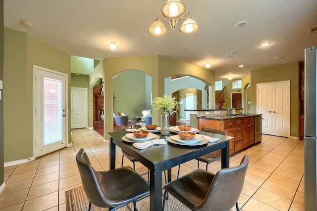 dining space featuring baseboards, visible vents, arched walkways, and light tile patterned flooring