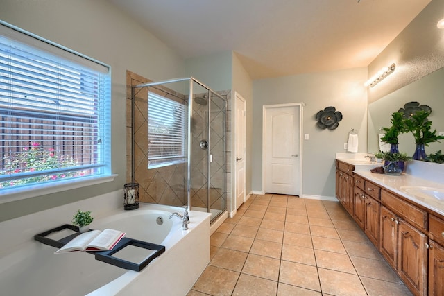 full bath with a sink, double vanity, a stall shower, a garden tub, and tile patterned flooring