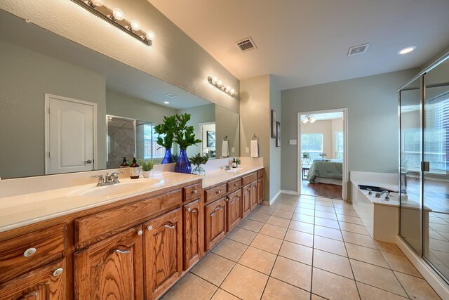 full bath with a sink, a stall shower, tile patterned flooring, and visible vents