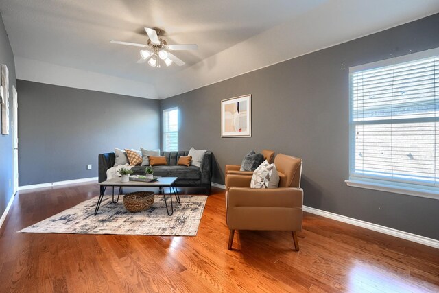living area featuring baseboards, wood finished floors, and ceiling fan