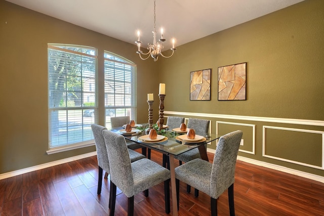 dining space featuring a notable chandelier, baseboards, wood finished floors, and a healthy amount of sunlight