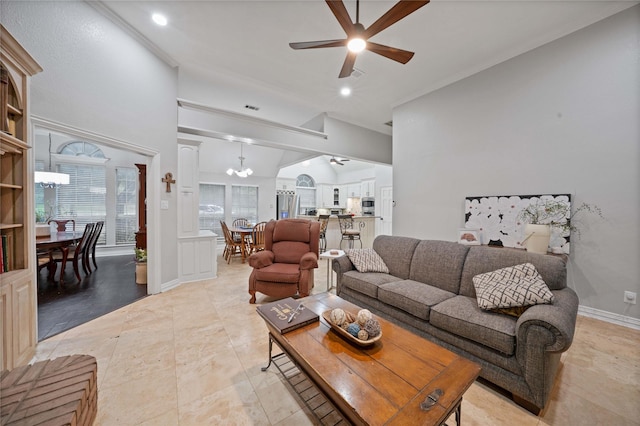 living area with vaulted ceiling and ceiling fan with notable chandelier