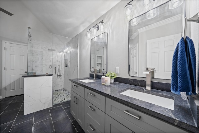 full bathroom with a stall shower, lofted ceiling, double vanity, and a sink