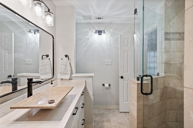 bathroom featuring visible vents, vanity, a stall shower, and baseboards