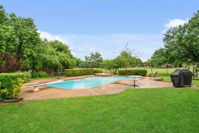 view of swimming pool with a patio, a diving board, fence private yard, a grill, and a lawn