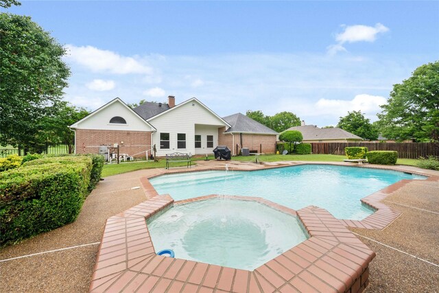 view of pool featuring a pool with connected hot tub and a fenced backyard