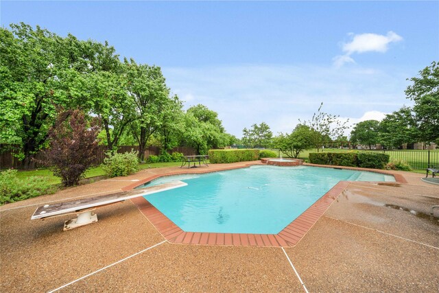 view of pool with a diving board, a patio, a pool with connected hot tub, and a fenced backyard