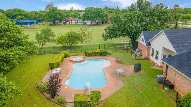view of swimming pool with central AC, a fenced backyard, a patio area, and a lawn