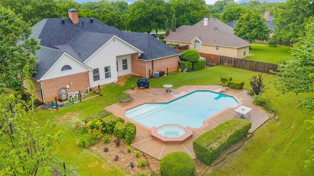view of swimming pool featuring a yard, a patio area, an in ground hot tub, and a fenced backyard