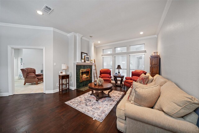 living room with hardwood / wood-style floors, a high end fireplace, baseboards, visible vents, and crown molding