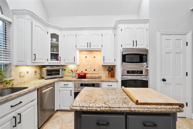 kitchen with a toaster, white cabinets, and stainless steel appliances